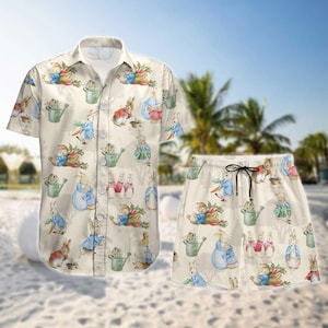 Puede incluir: Una camisa blanca de botones y pantalones cortos a juego con un patrón repetido de conejos y regaderas. Los conejos llevan ropa azul, roja y verde.