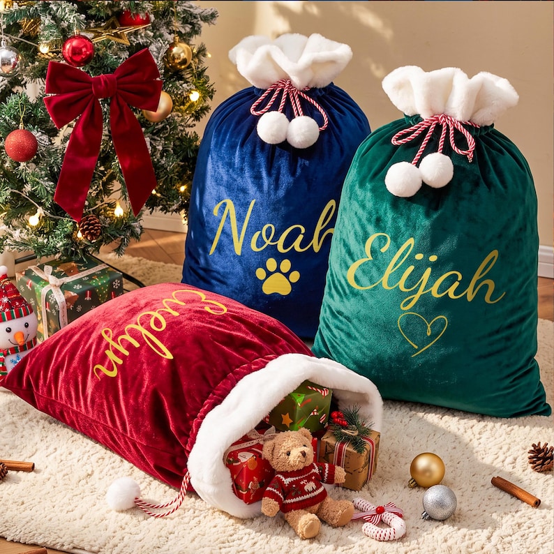 May include: Three velvet Christmas gift sacks in red, blue, and green, each featuring a white faux fur cuff and drawstring with pom-poms. The sacks are personalized with gold script names: Evelyn, Noah, and Elijah, along with a paw print and heart.
