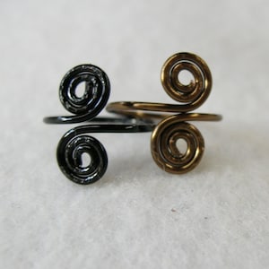 May include: Two wire rings, one black and one gold, with a double spiral design.