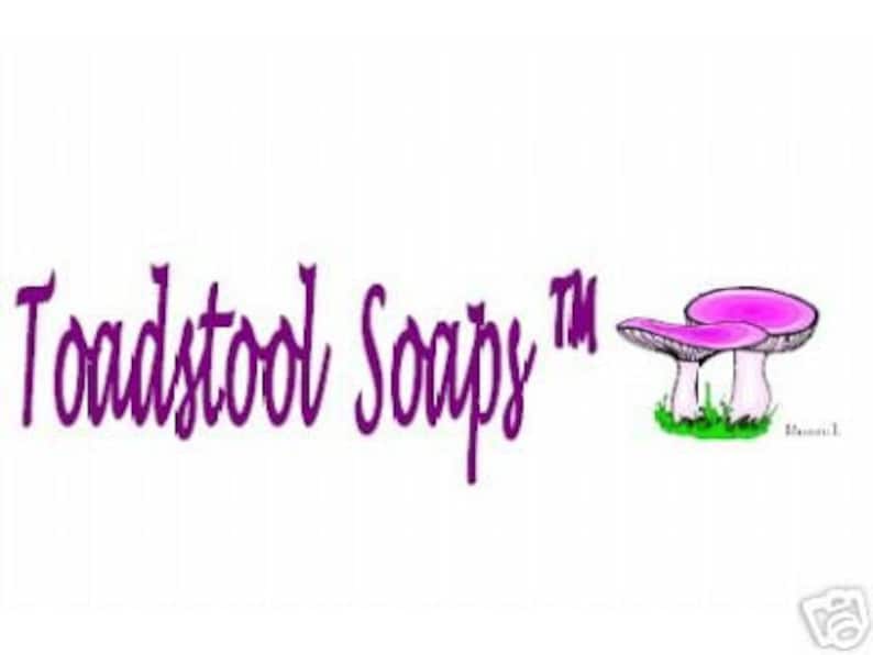 May include: Purple text reads "Toadstool Soapy" with a trademark symbol. The text is followed by a cartoon image of two pink mushrooms with white stems.