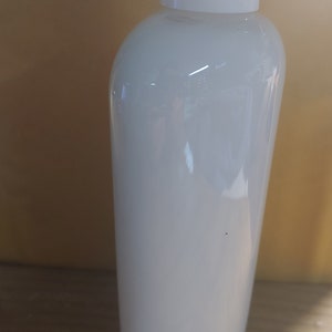 May include: White plastic bottle with a white cap. The bottle is opaque and has a smooth surface.
