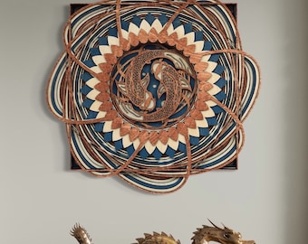 May include: A wooden wall art piece with a circular design featuring two fish in a swirling pattern. The design is layered and has a 3D effect. The colors are blue, brown, and white.