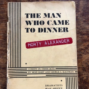 Puede incluir: Un guion de obra de teatro vintage para "The Man Who Came to Dinner" de Moss Hart y George S. Kaufman. La portada es de color crema con rayas negras y blancas y una etiqueta roja con el nombre "Morty Alexander".