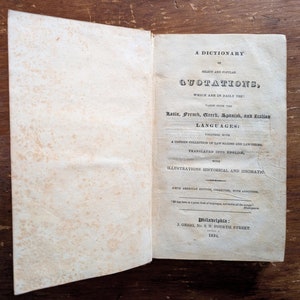 Könnte beinhalten: Ein altes Buch mit dem Titel "A Dictionary of Select and Popular Quotations, Which Are in Daily Use!"  Entnommen aus dem Lateinischen, Französischen, Griechischen, Spanischen und Italienischen : Eine umfangreiche Sammlung von Rechtsmaximen und Rechtsbegriffen, übersetzt ins Englische, mit historischen und idiomatischen Illustrationen.  Neue amerikanische Ausgabe, korrigiert, mit Zusätzen.  Veröffentlicht in Philadelphia von J. Grigg, No. 9 N. Fourth Street im Jahr 1831.