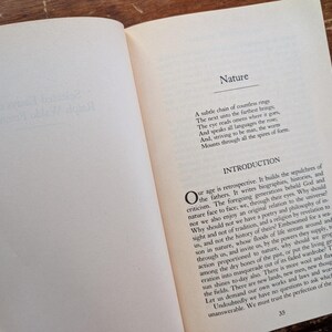 K&ouml;nnte beinhalten: Ein offenes Buch mit wei&szlig;em Hintergrund und schwarzem Text. Das Buch tr&auml;gt den Titel "Natur" und der Text behandelt die Natur unseres Zeitalters und unsere Beziehung zum Universum. Der Text enth&auml;lt den Satz "Unser Zeitalter ist retrospektiv."