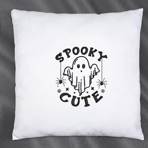 May include: White pillow with black embroidery of a ghost with the text "Spooky Cute" and two spiders.