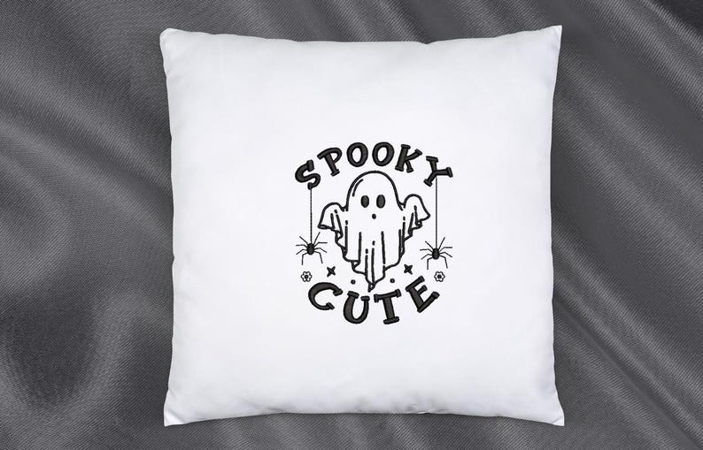 May include: White pillow with black embroidery of a ghost with the text "Spooky Cute" and two spiders.