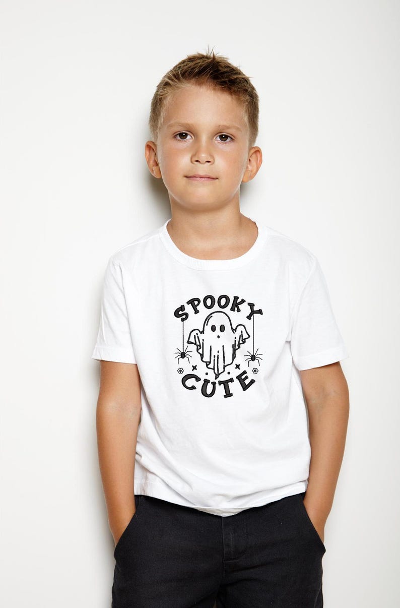 May include: A white t-shirt with a black graphic of a ghost with the text "Spooky Cute" and spiders.