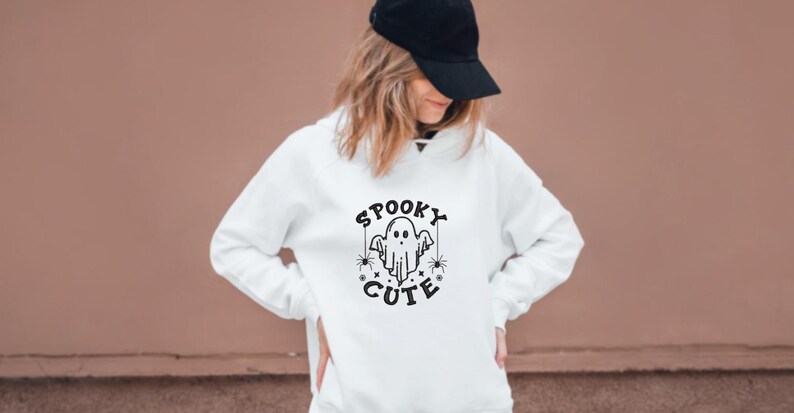 May include: White hoodie with a black graphic of a ghost with the text "Spooky Cute" on it.