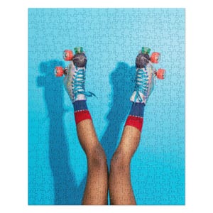 May include: A pair of legs wearing blue and white roller skates with red and white socks against a bright blue background.