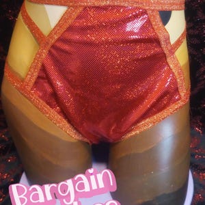 May include: Red sequined shorts with orange trim and crisscross accents. The shorts are displayed on a mannequin. The text "Bargain Babes" is visible in a pink font.