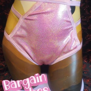 May include: Pink glittery underwear with light pink trim and straps. The underwear is displayed on a mannequin. The text "Bargain Babes" is in a pink and white font at the bottom of the image.