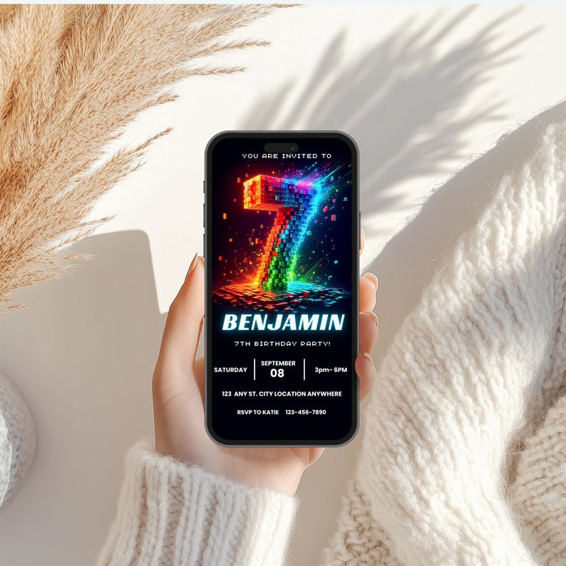 May include: A smartphone screen displaying a digital birthday invitation with a large, glowing, pixelated number 7 in rainbow colors. The text reads: YOU ARE INVITED TO, BENJAMIN, 7TH BIRTHDAY PARTY, SATURDAY, SEPTEMBER 08, 3pm-6PM, 123 ANY ST. CITY LOCATION ANYWHERE, RSVP TO KATIE 123-456-7890.