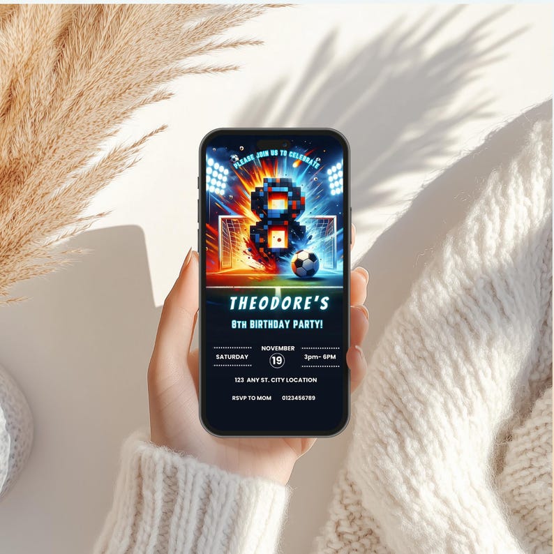 Op de afbeelding: Een smartphone toont een uitnodiging voor een verjaardagsfeestje met voetbalthema. De uitnodiging toont een gepixelde 8, voetbaldoelen en een voetbal. De tekst luidt "Theodore's 8e verjaardagsfeest!" met datum, tijd en locatie details.