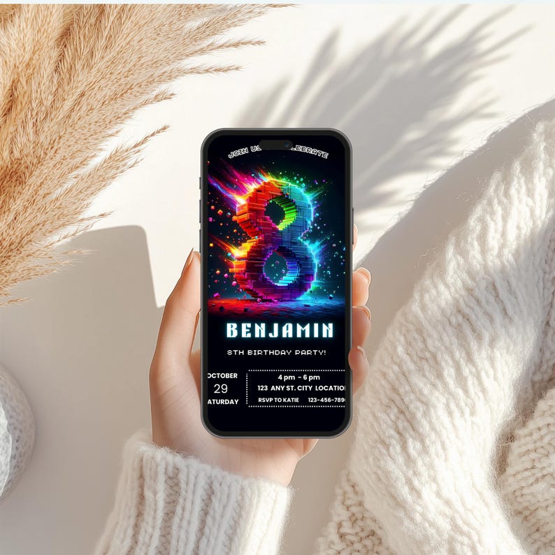 May include: A smartphone displaying a digital birthday invitation featuring a large, glowing, multi-colored number eight. The text reads: JOIN US TO CELEBRATE, BENJAMIN, 8TH BIRTHDAY PARTY, OCTOBER 29 SATURDAY, 4 pm - 6 pm, 123 ANY ST. CITY LOCATION, RSVP TO KATIE 123-456-7890.