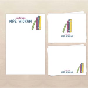 May include: White stationery set with the text "a note from MRS. WICKAM" and a colorful illustration of stacked books. The set includes a notepad and several notecards, perfect for sending personalized messages.