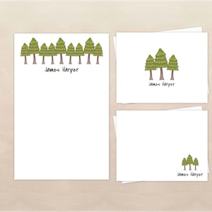 May include: A stationery set featuring a white background with a green tree design. The set includes a large sheet of paper, a small card, and an envelope. The name "James Harper" is printed on each piece.