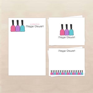 May include: Stationery set featuring a pink, purple, and blue nail polish bottle design. The set includes a notepad, notecards, and a smaller card, all with the name "Maggie Stewart" printed on them.