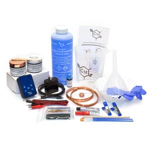 May include: A copper electroforming starter kit with various components. Includes a blue electroforming solution bottle, copper wire coils, a blue control box, brushes, and a funnel. The kit also contains a measuring cup, gloves, and other supplies.