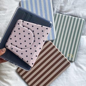 Detachable magnetic back Kindle case with clear cover and printed polka dot design. Rotating stand compatible Kindle Paperwhite case allowing easy attachment and removal while protecting the device.