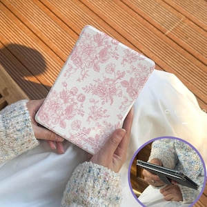 May include: A white tablet case featuring a pink floral design. The case is rectangular and held in hands. The word "Francesca" is printed on the case. The case is designed to protect a tablet.