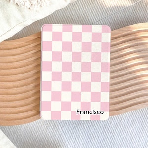 May include: A pink and white checkered notebook with the name "Francisco" printed on the front.