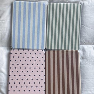Retro patterned Kindle case collection showing Blue Stripe, Sage Stripe, Pink Polka Dot and Brown Stripe designs. Personalized Kindle cover styles for book lovers, compatible with Kindle Paperwhite, Kindle 2024 and Kindle Colorsoft devices.