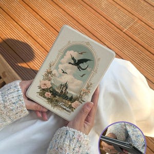 May include: A rectangular case with a fantasy landscape design featuring a castle, dragons, and floral accents. The case has a light beige background with the word "Francisco" in script. The case is held in a person's hands.