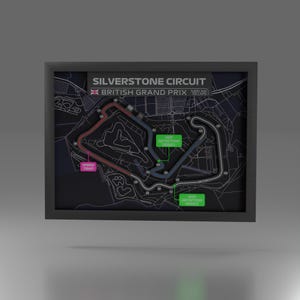May include: Framed map of the Silverstone Circuit, host of the British Grand Prix. The black and white map features colored track sections, including red, blue, and green, with text labels for speed traps and DRS detection zones. The frame is black.