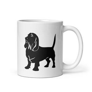 May include: White ceramic mug with a black silhouette of a Basset Hound dog.