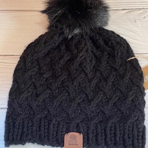 Women’s Hand Knit Criss Cross Style Hat in Black with Black Faux Fur Pom