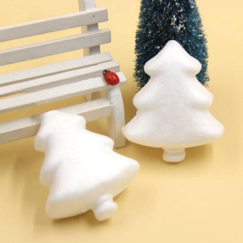 May include: Two white foam Christmas tree shapes. The trees are approximately 7.5 cm tall and are ideal for crafting.