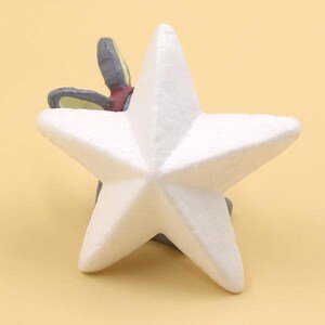 May include: A white foam five-pointed star with a gray and yellow rabbit figurine partially hidden behind it.