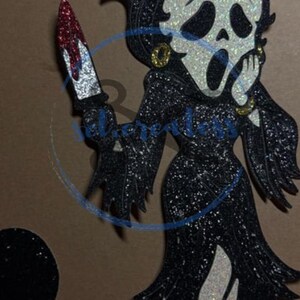 Puede incluir: Un personaje de dibujos animados en blanco y negro brillante con un vestido negro, sosteniendo un cuchillo ensangrentado. El personaje tiene una cara de m&aacute;scara de grito y lleva pendientes dorados. La palabra "SVG" est&aacute; escrita en blanco en la parte superior.