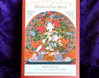 May include: A red box for the Celestial Gallery Meditation Deck. The box features an illustration of a meditating figure surrounded by flowers. Text on the box includes the deck name, author Romio Shrestha, and the number of cards.