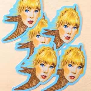 May include: Five colorful stickers featuring a blonde woman with a bird's wings. Each sticker has a blue background and features a different pose of the woman.