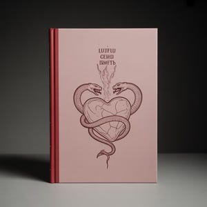 Può includere: Un libro con copertina rigida rosa con un'illustrazione dettagliata. Due serpenti si avvolgono attorno a un cuore. Il dorso del libro è rosso e c'è del testo nella parte superiore.
