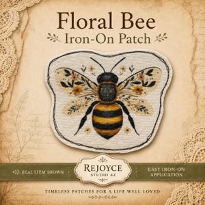 May include: An iron-on patch featuring a bee with wings decorated in floral patterns. The bee has a black and yellow striped body. The text reads Floral Bee Iron-On Patch, Rejoyce Studio AZ, Real Item Shown, Easy Iron-On Application, Timeless Patches For A Life Well Loved.