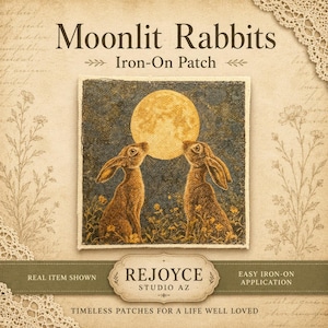 May include: A square iron-on patch featuring two brown rabbits facing a large yellow full moon against a dark blue night sky with small yellow flowers at the base. The text reads Moonlit Rabbits Iron-On Patch, REJOYCE STUDIO AZ, and more.