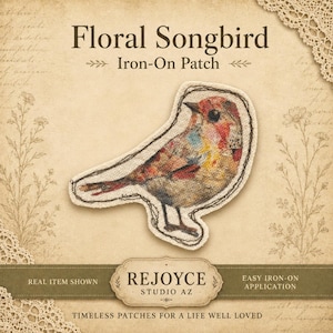 May include: An iron-on patch featuring a songbird with a textured, multi-colored plumage of red, yellow, and brown tones. The patch is displayed on a tan background with the text Floral Songbird Iron-On Patch and Rejoyce Studio AZ.
