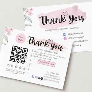 May include: Two white business thank you cards with a pink watercolour brushstroke and floral accents. The cards include a QR code, social media icons, and the text "Thank you" in a handwritten font.