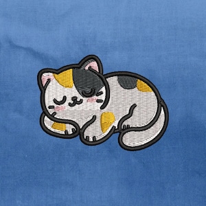 May include: Embroidered patch of a sleeping cat with a black outline. The cat has patches of yellow, black, and grey fur, with closed eyes and a pink nose. The patch is set against a blue background.