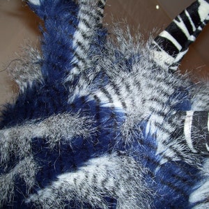 May include: A blue and white striped furry hat with a long, black and white striped tail.