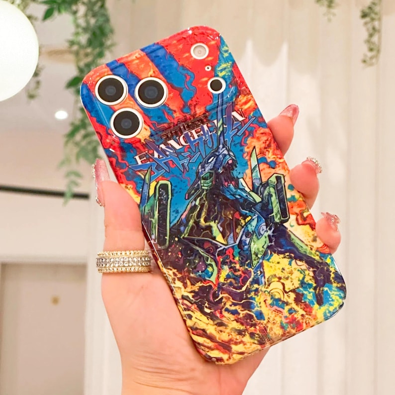 May include: A colorful phone case featuring a vibrant design with the text "EVANGELION". The case showcases a dynamic illustration with shades of red, blue, yellow, and green. The case has multiple camera cutouts.