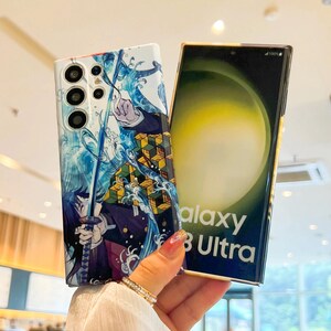 Pu&ograve; includere: Una custodia per telefono bianca con un design di personaggio anime blu e verde. La custodia presenta una spada e onde d'acqua. La custodia per telefono &egrave; mostrata su un telefono Samsung Galaxy S8 Ultra.