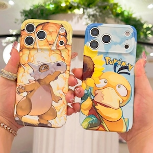 Op de afbeelding: Twee telefoonhoesjes met cartoonontwerpen. Eén hoesje heeft een geel en oranje achtergrond met een dinosaurusachtig wezen. De andere hoes heeft een blauwe achtergrond met een geel eendachtig karakter en het woord "Pokemon".