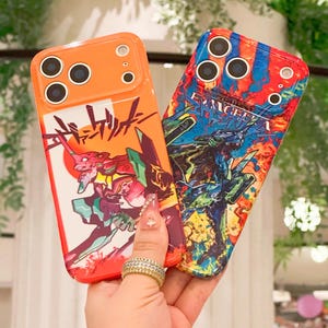 May include: Two phone cases with colorful anime-style graphics. One case is orange with a red and green character design and Japanese text. The other case is blue, red, and yellow with a robot graphic and the word "EVANGELION".