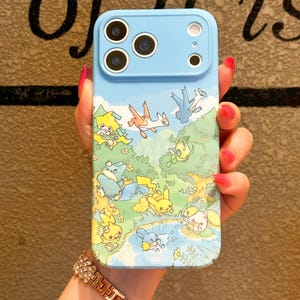 Può includere: Una custodia per smartphone azzurra con una stampa grafica colorata di varie creature animate in un ambiente boschivo. La custodia presenta una sezione rialzata per la fotocamera nella parte superiore con tre aperture circolari e due fori.