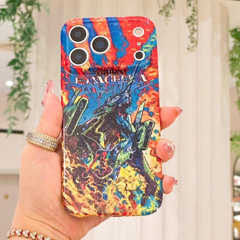 May include: A colorful phone case featuring a vibrant design with the text "EVANGELION" and a graphic of a robot. The case has a mix of red, blue, yellow, and green colors.