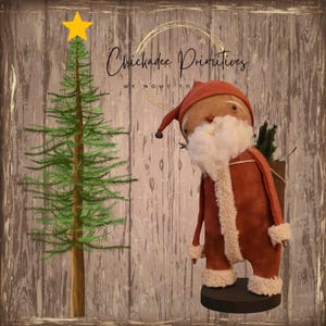May include: A fabric Santa Claus figurine in a rust-coloured suit with white faux fur trim, a matching hat, and a white beard, standing on a black circular base. Beside it is a green illustrated Christmas tree with a yellow star on top.